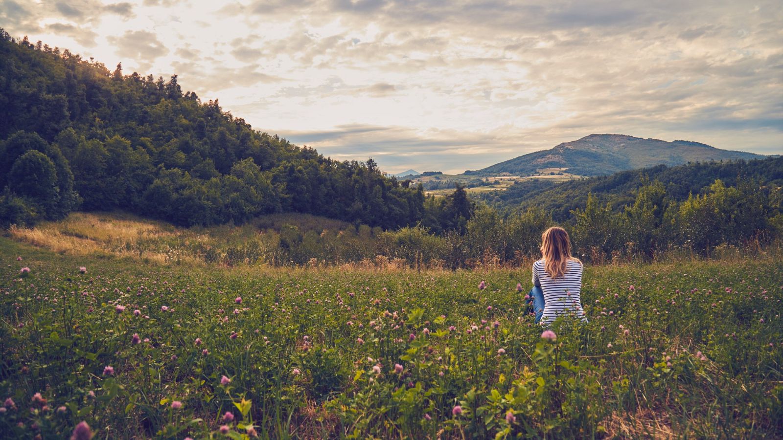 Astenia primaveral: Una mujer contempla el paisaje en primavera