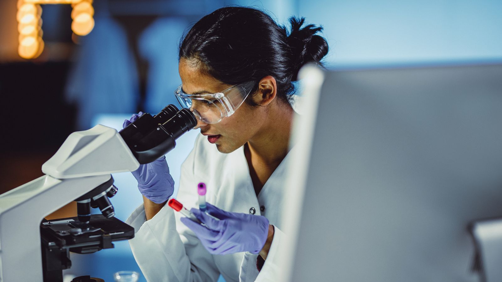 Una científica utiliza el microscopio