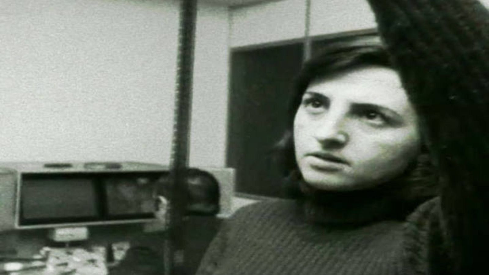 La periodista Carmen Sarmiento revisando una tira de película al trasluz y, al fondo, Manuel Yébenes trabaja en la moviola los planos seleccionados previamente