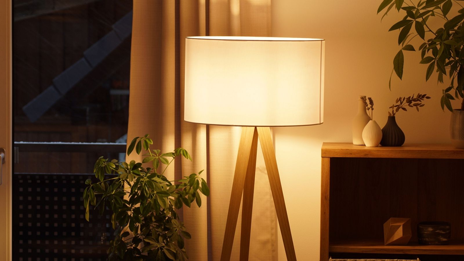 Una lámpara encendida en el salón de una vivienda