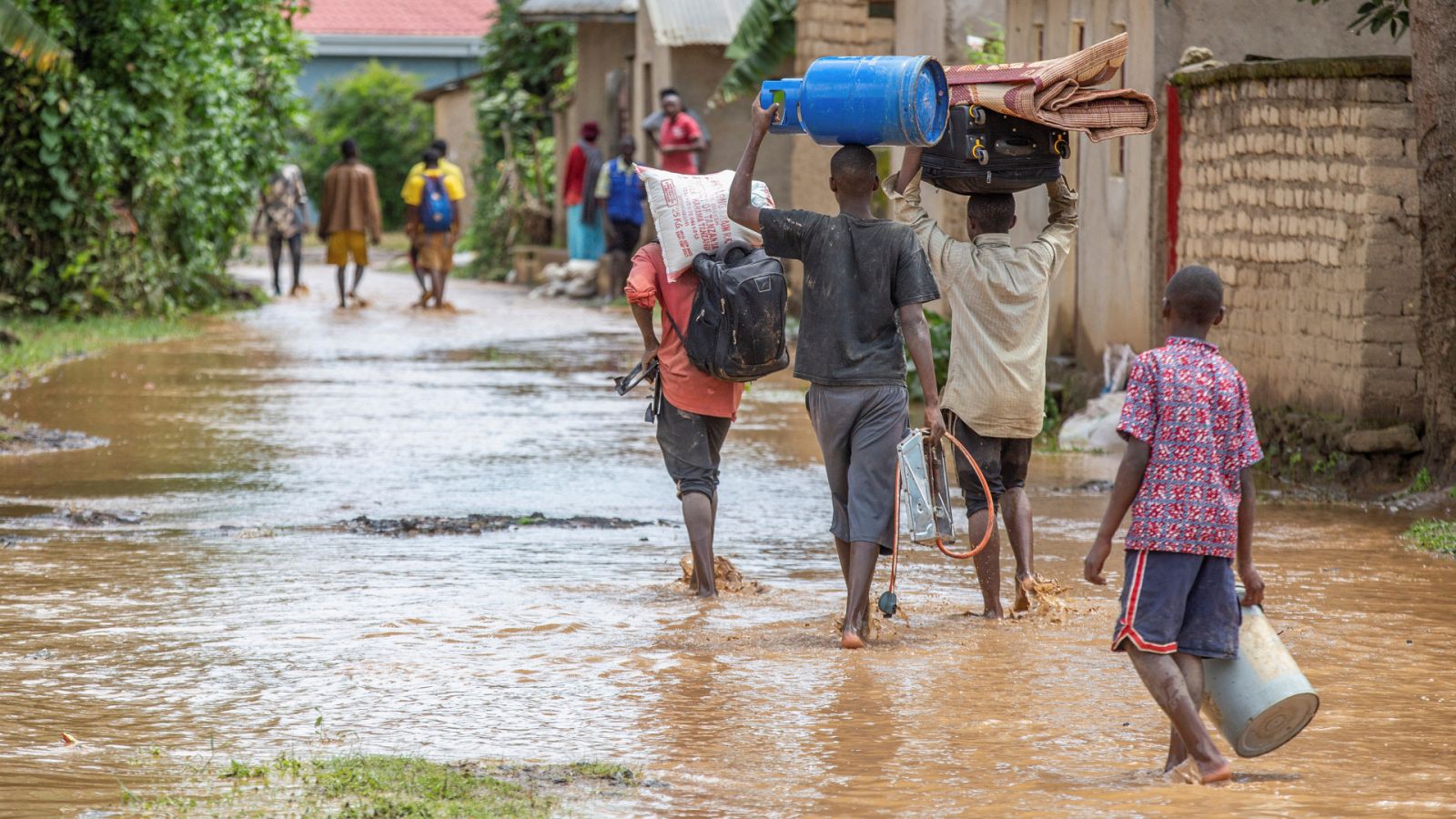 Niños ruandeses andan sobre caminos inundados