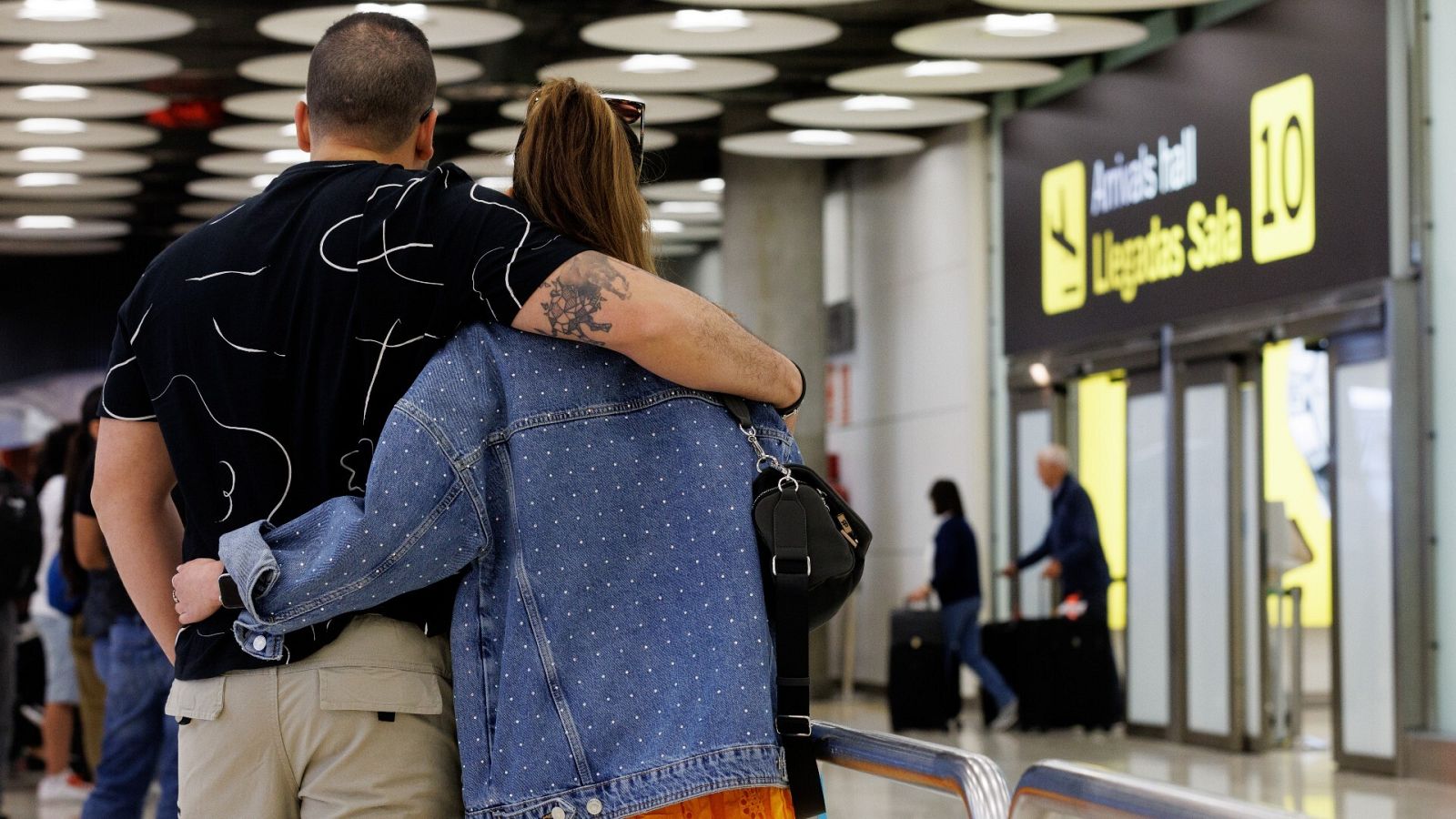 Una pareja espera en la T4 de Barajas