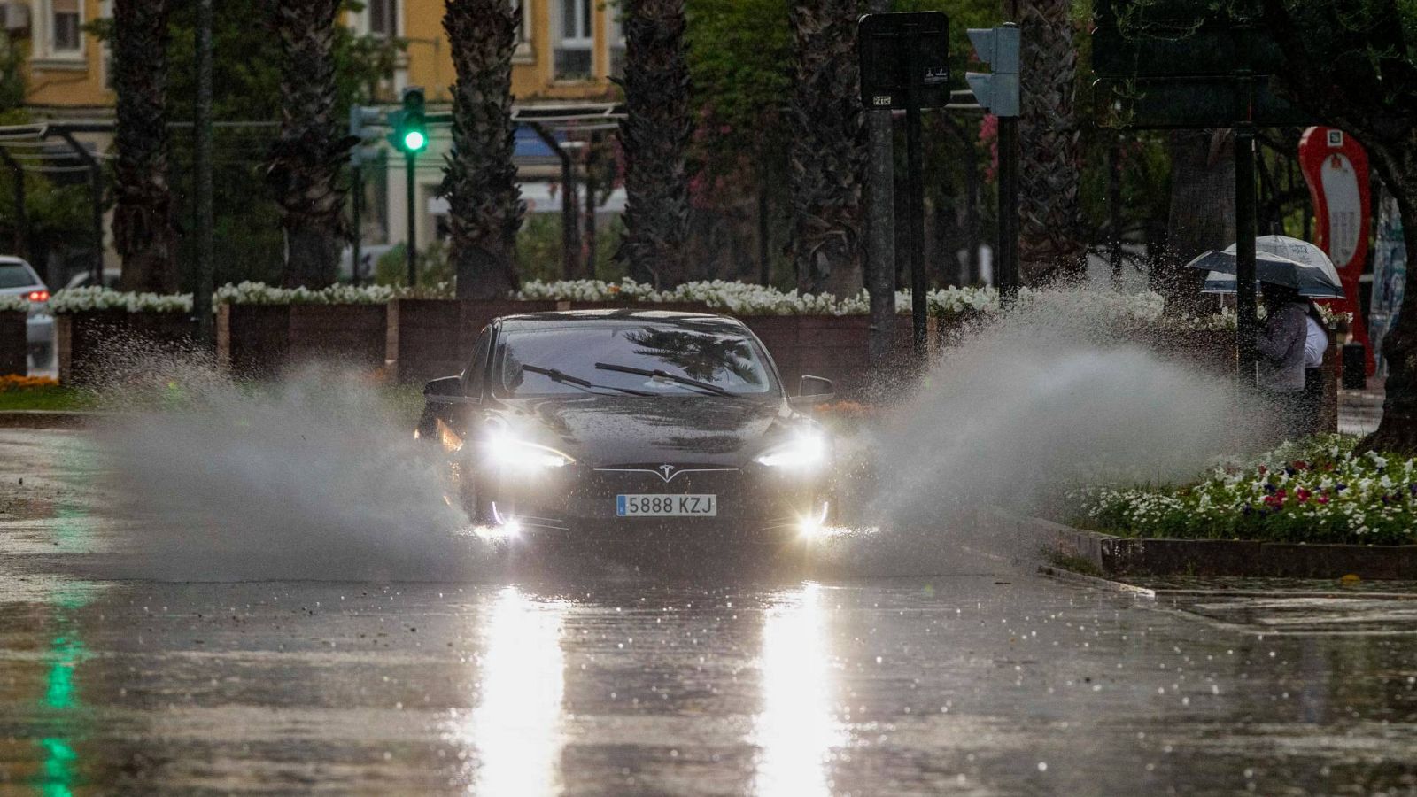 Un coche levanta el agua de la lluvia caída en la tarde de este domingo en la ciudad de Murcia