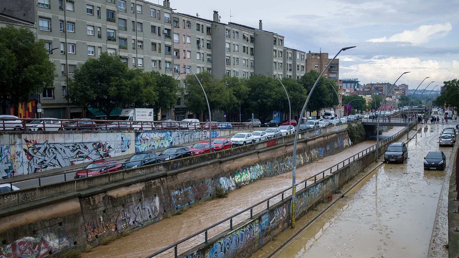 Varios coches se quedan atascados en la vía por las inundaciones en las calles de Terrassa