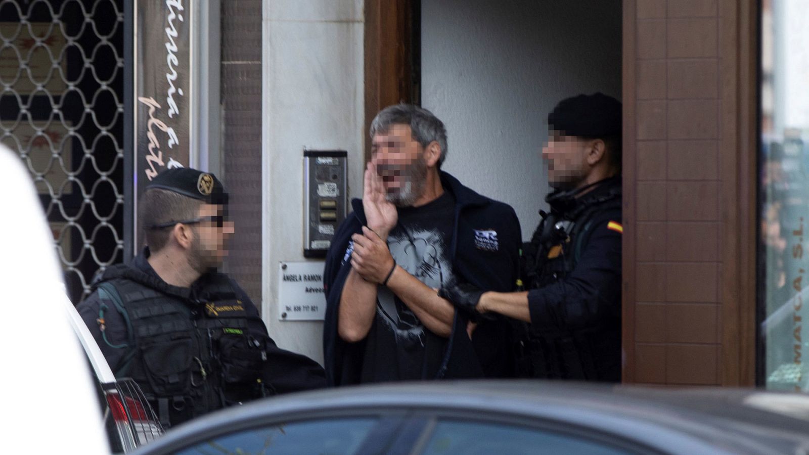 Agentes de la Guardia Civil acompañan a uno de los CDR detenidos durante un registro
