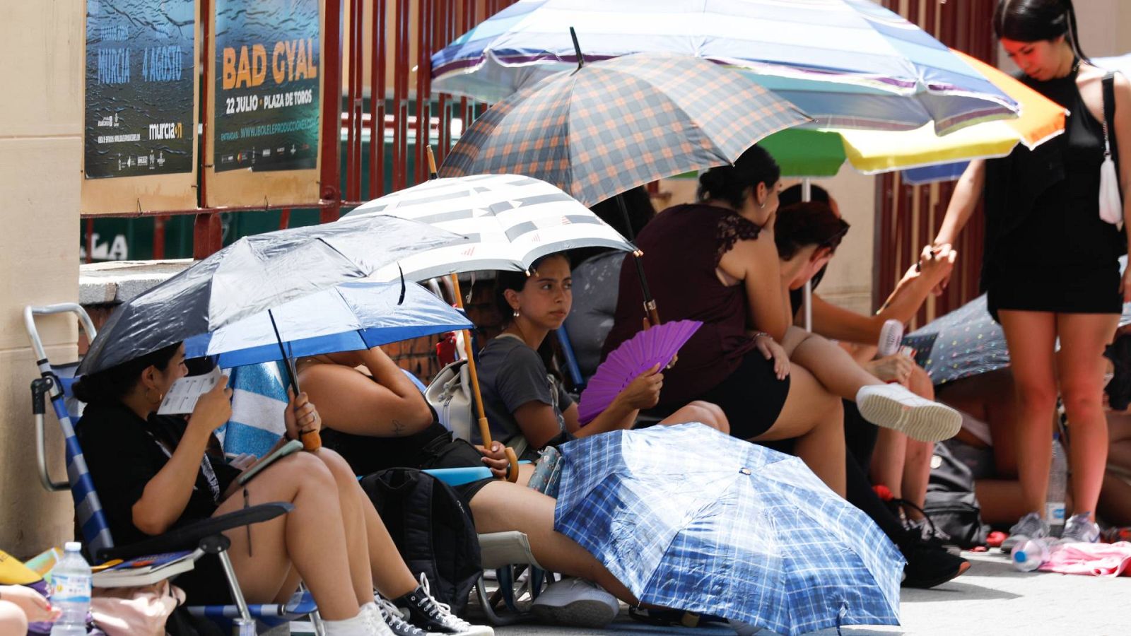 Varias personas se refugian del calor bajo paraguas en Murcia