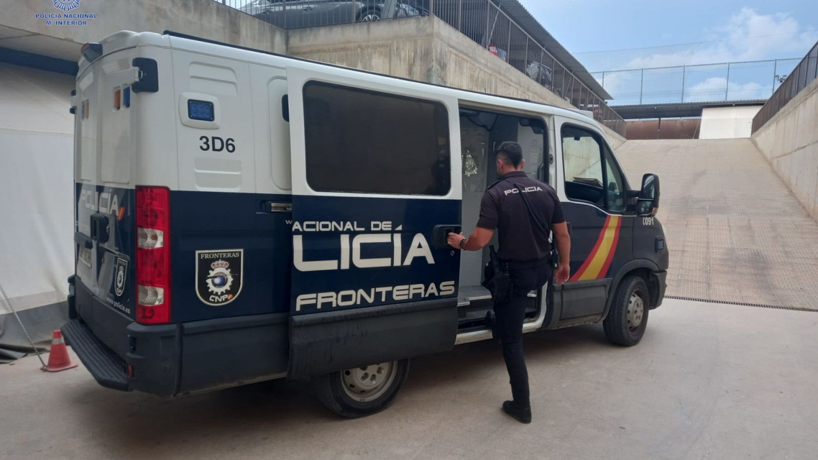 Un agente de la Policía Nacional junto a un furgón