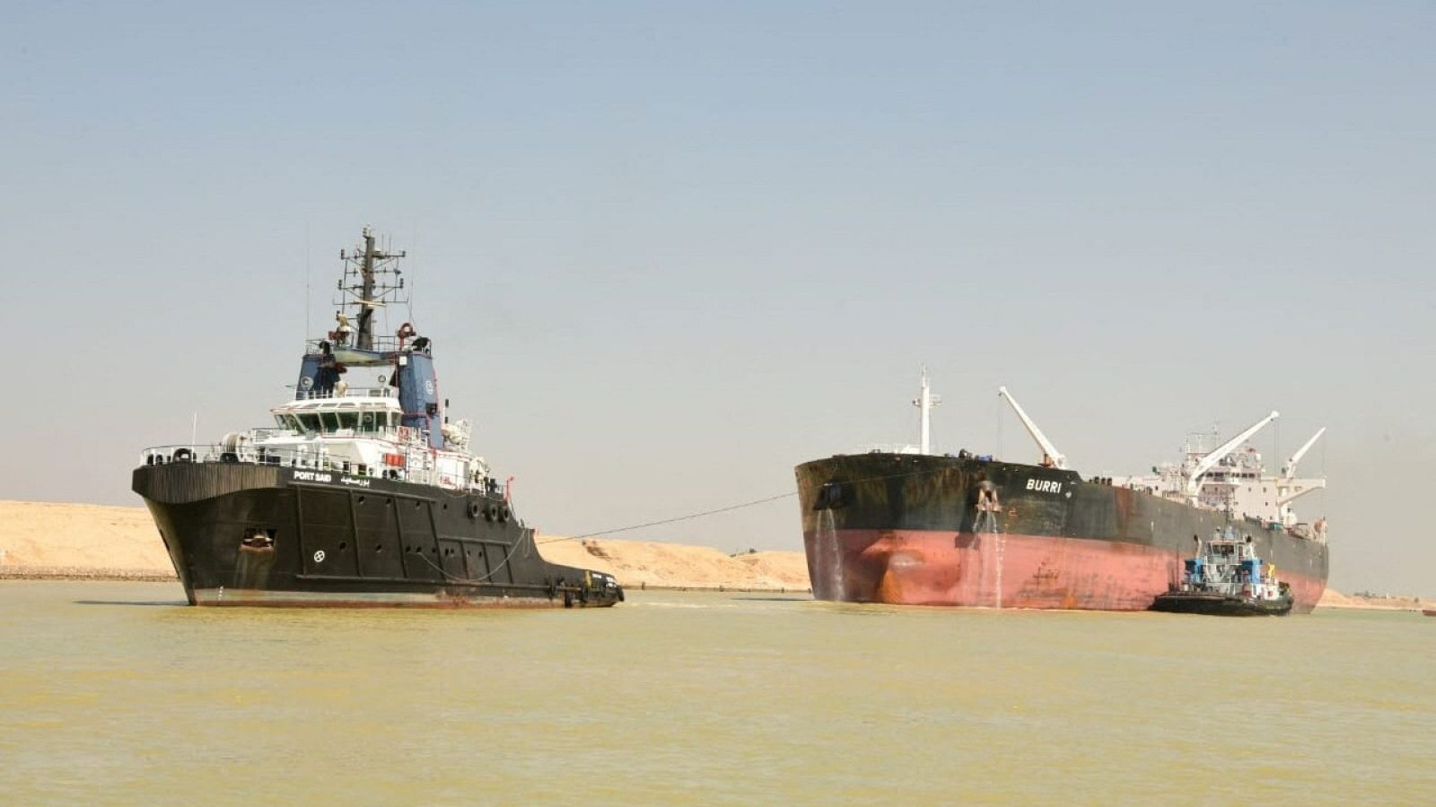 A tugboat works to refloat the Oil Products Tanker BURRI after it collided with LNG Tanker BW Lesmes in Suez Canal