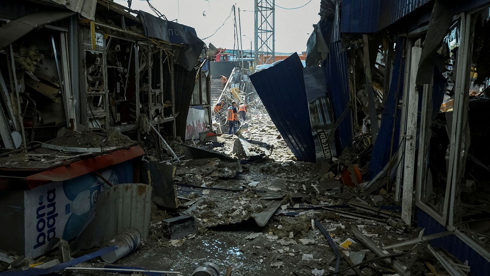 Trabajadores municipales limpian la zona destruida durante un ataque militar ruso, en medio del ataque de Rusia a Ucrania, en Dnipro