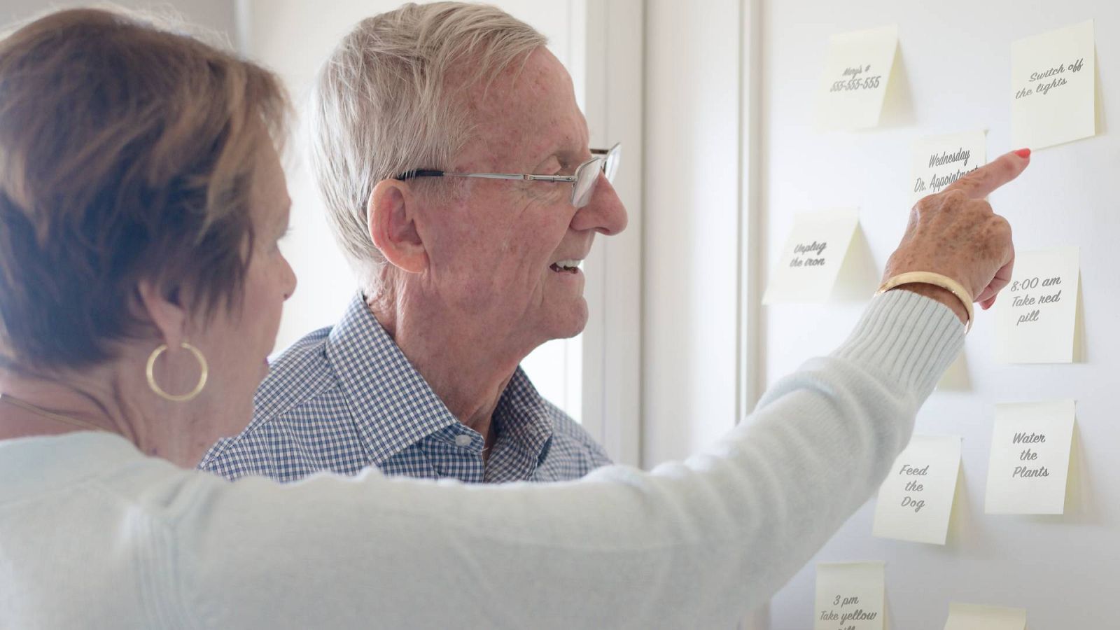 Una mujer le anota las tareas diarias a su marido