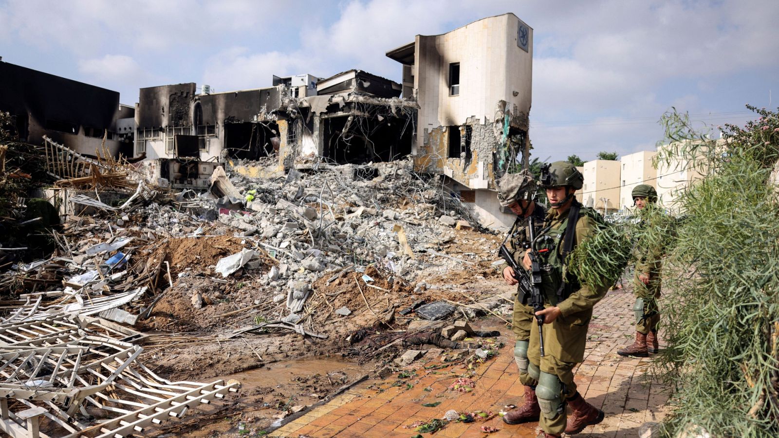 Soldados israelíes frente a una comisaria derrumbada