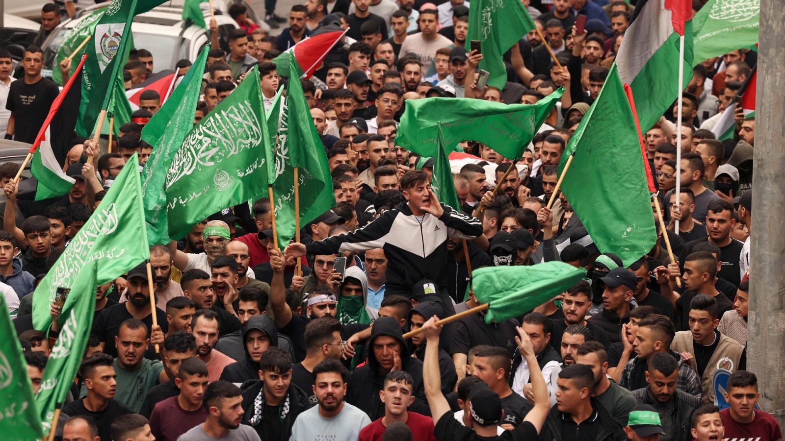 Palestinos ondeando banderas nacionales y de Hamás