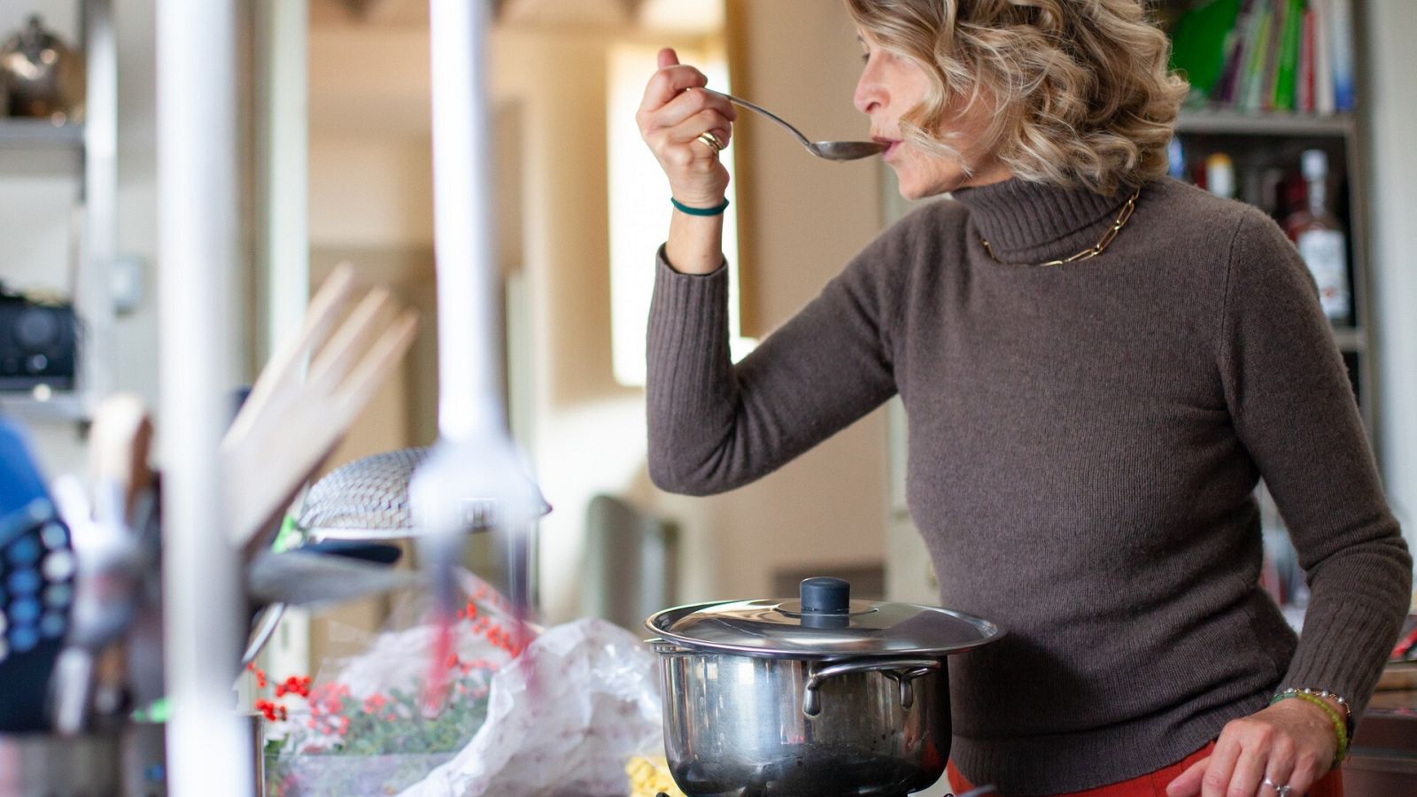 Una mujer prueba una sopa con una cuchara