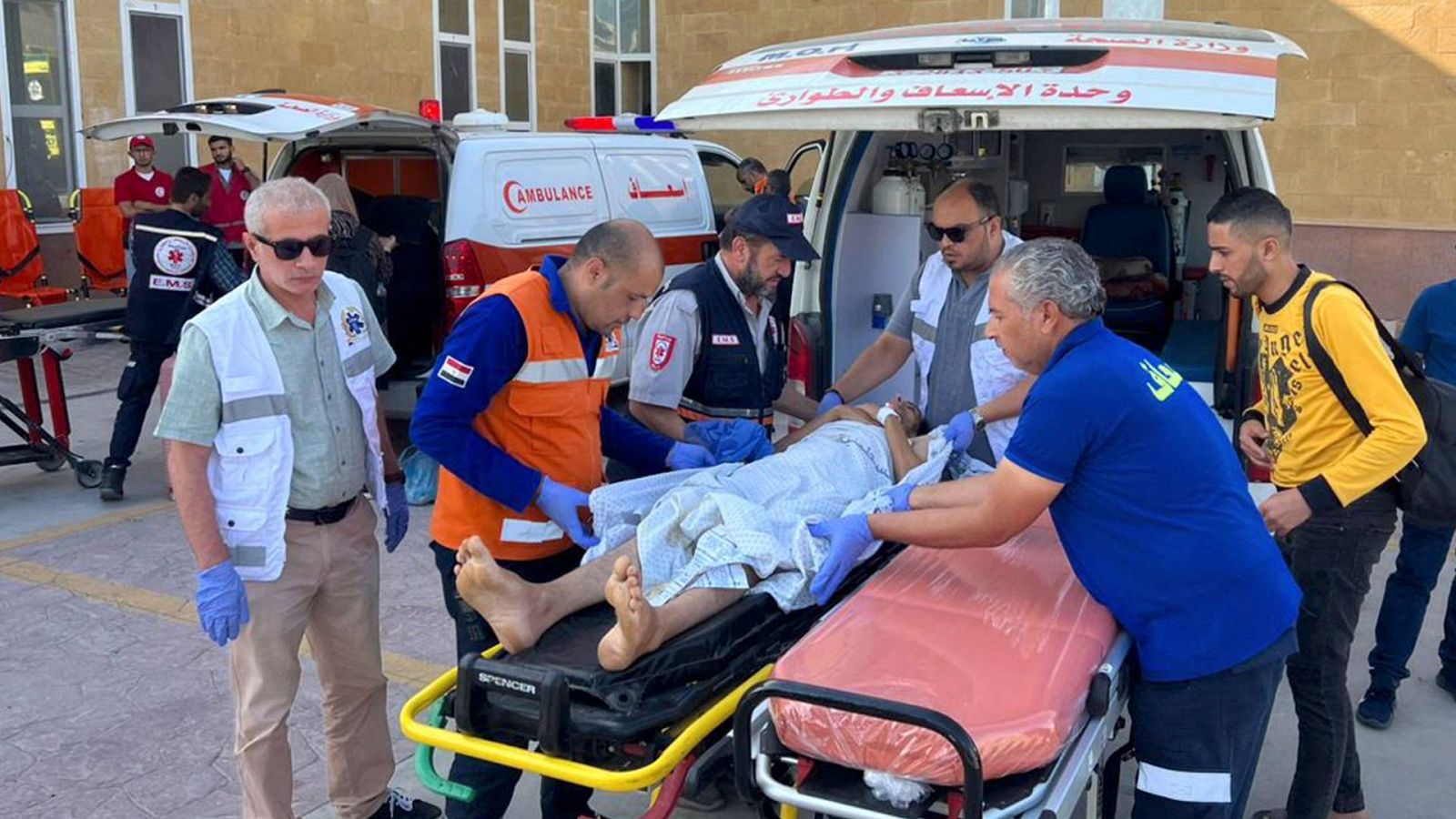 El personal médico egipcio traslada a palestinos heridos en el lado egipcio del cruce fronterizo de Ráfah