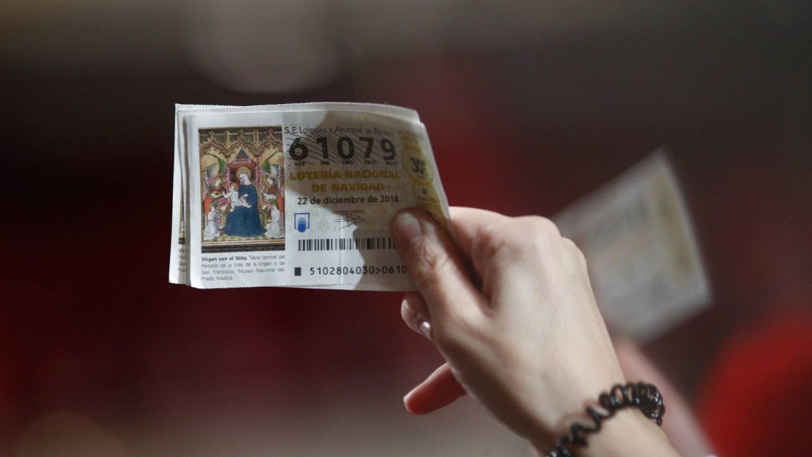 Lotería de Navidad 2023: una mujer sujeta sus décimos antes de comenzar Sorteo de la Lotería de Navidad