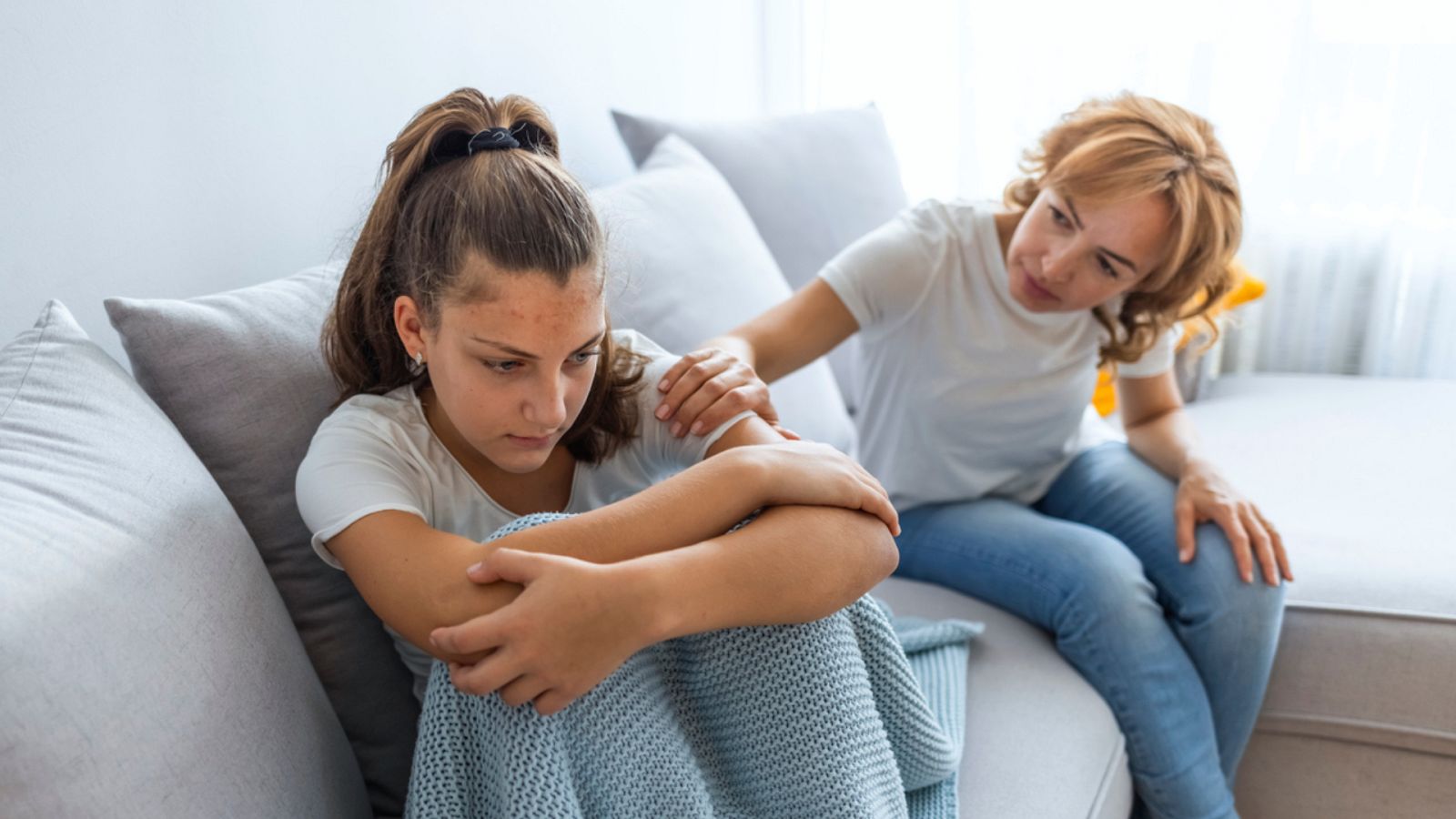 Madre estricta regañando a su hija adolescente infeliz en casa