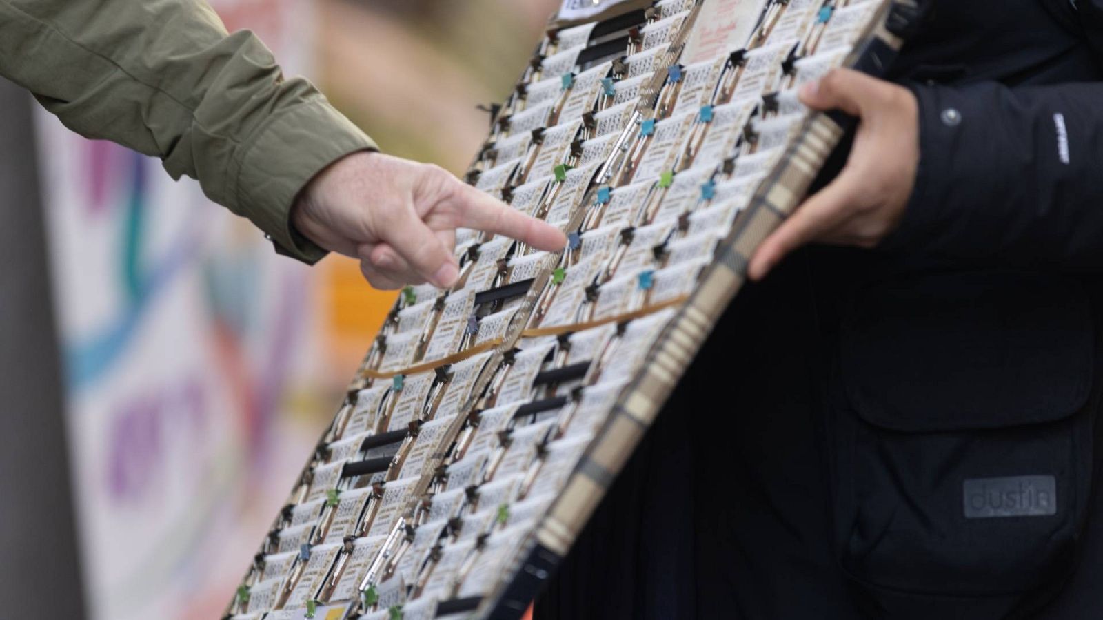 Lotería de Navidad 2023: una persona elige un décimo de la administración de lotería Doña Manolita