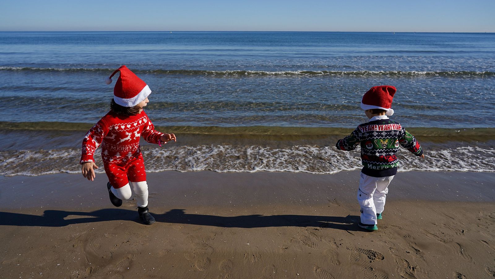Unos niños juegan en la playa de Valencia