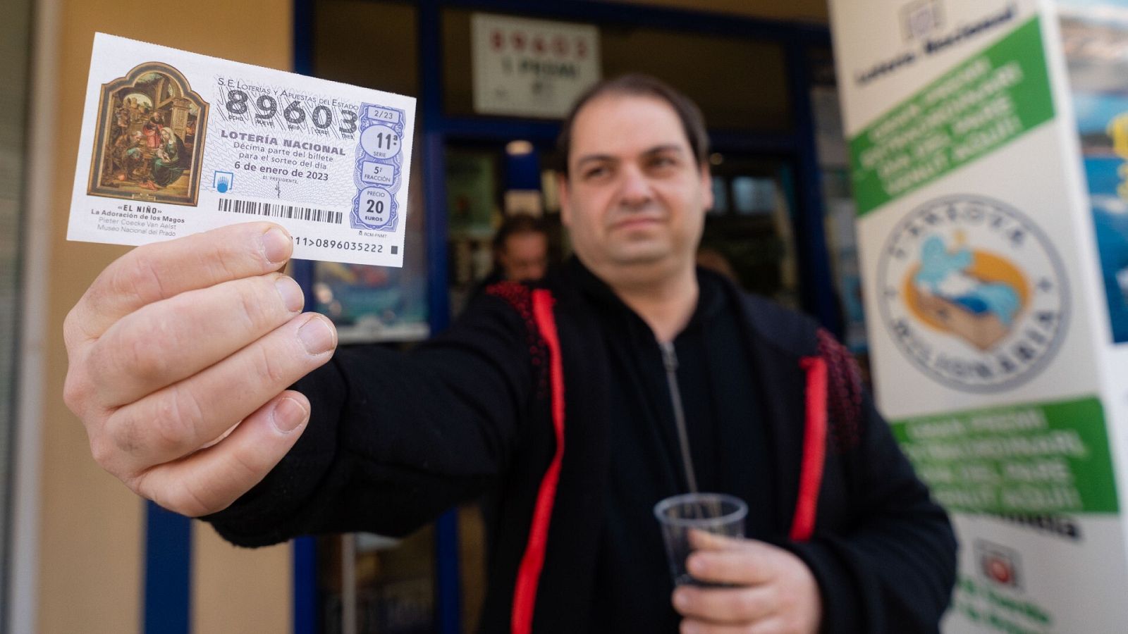 Lotería del Niño 2024: Un agraciado posa con su décimo