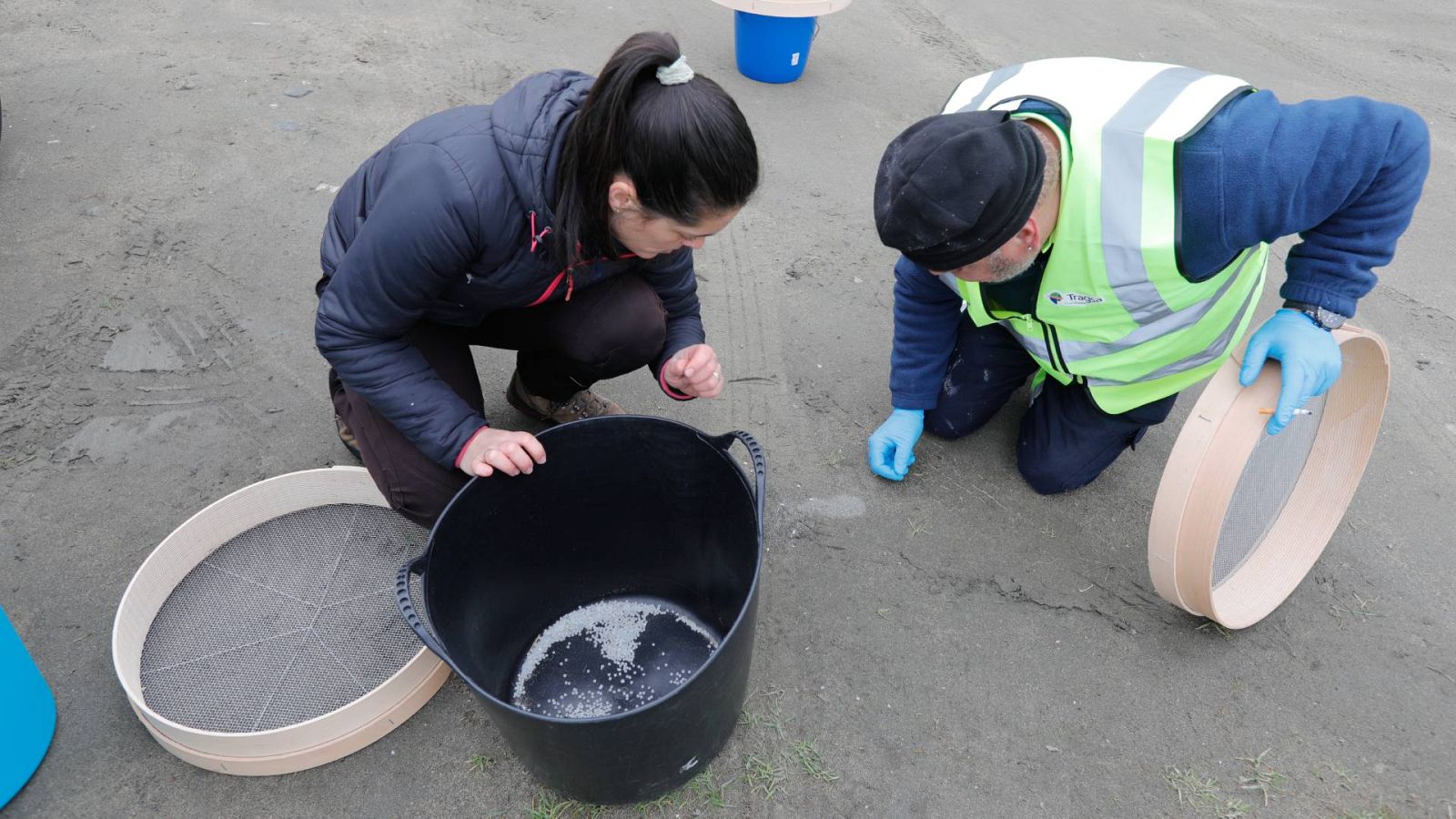 Operarios de TRAGSA recogen pellets de plástico, en la playa Otur
