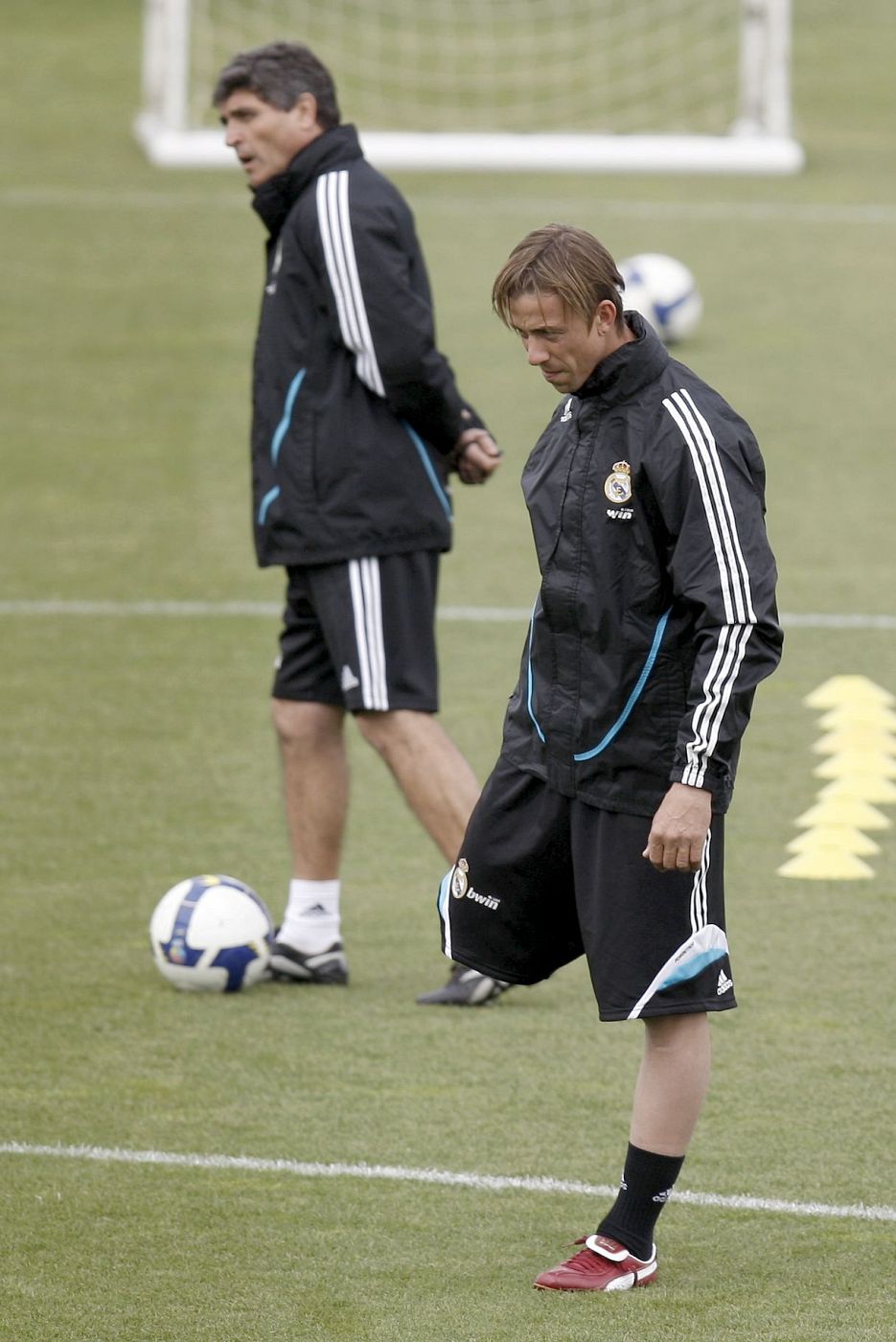 El jugador del Real Madrid José María Gutiérrez 'Guti' hace estiramientos junto al técnico, Juande Ramos, durante un entrenamiento.