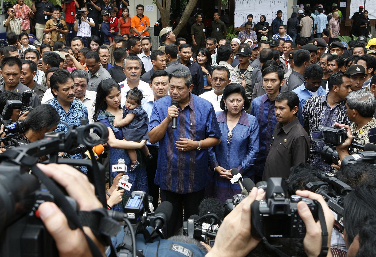 Indonesian President Yudhoyono accompanied by first lady Kristiani Yudhoyono speaks to journalists after casting his ballot in a polling station near his residence in Cikeas