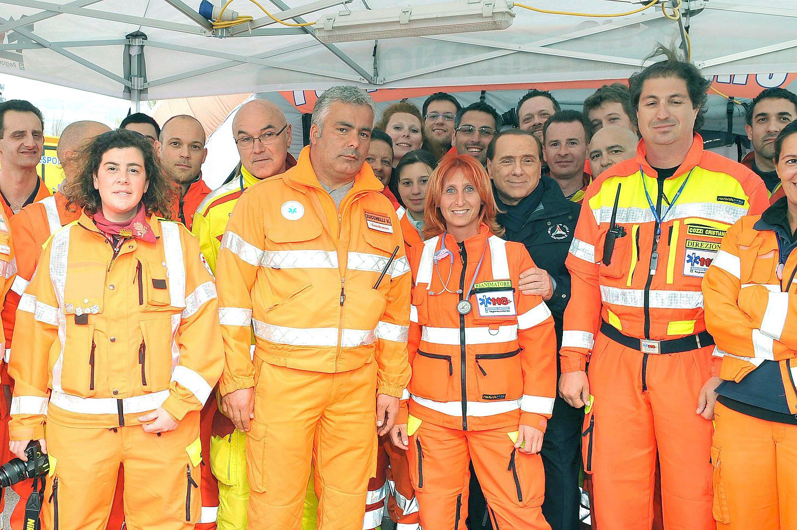 EL PRIMER MINISTRO ITALIANO, SILVIO BERLUSCONI, POSA PARA UNA FOTO DE FAMILIA JUNTO AL PERSONAL DE PROTECCIÓN CIVIL