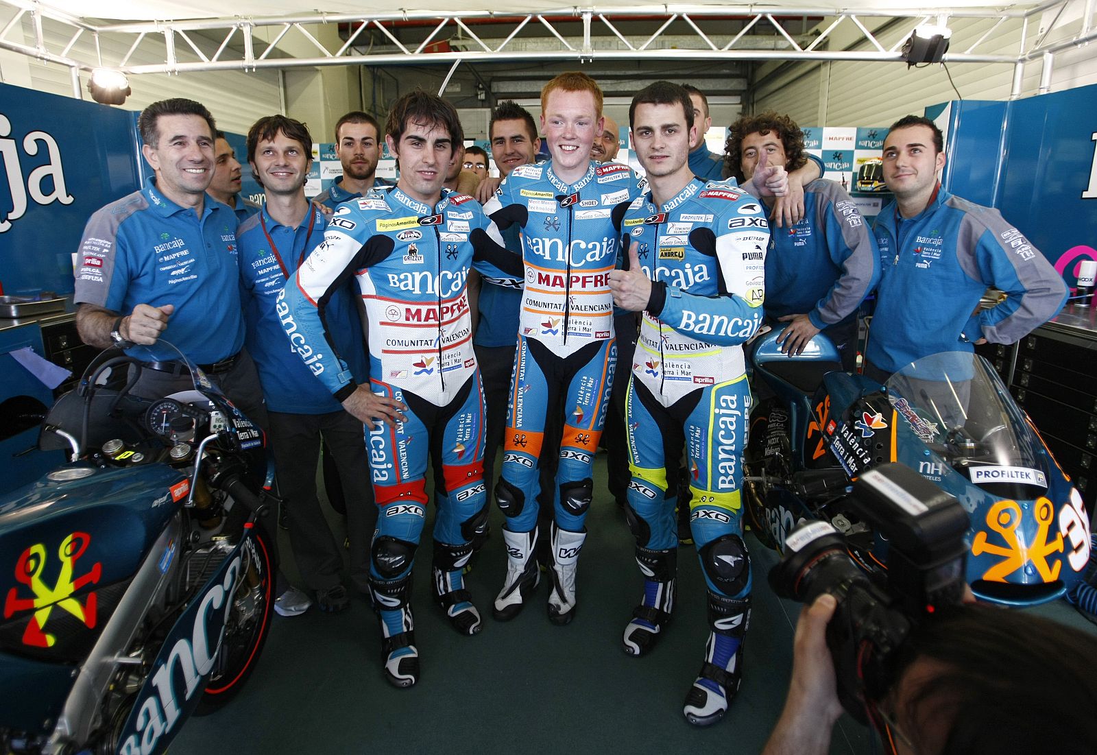 Aprilia 125cc riders Julian Simon of Spain, Bradley Smith of Britain and Sergio Gadea of Spain pose with their team after finishing the qualifying practice session of the Spanish Grand Prix in Jerez