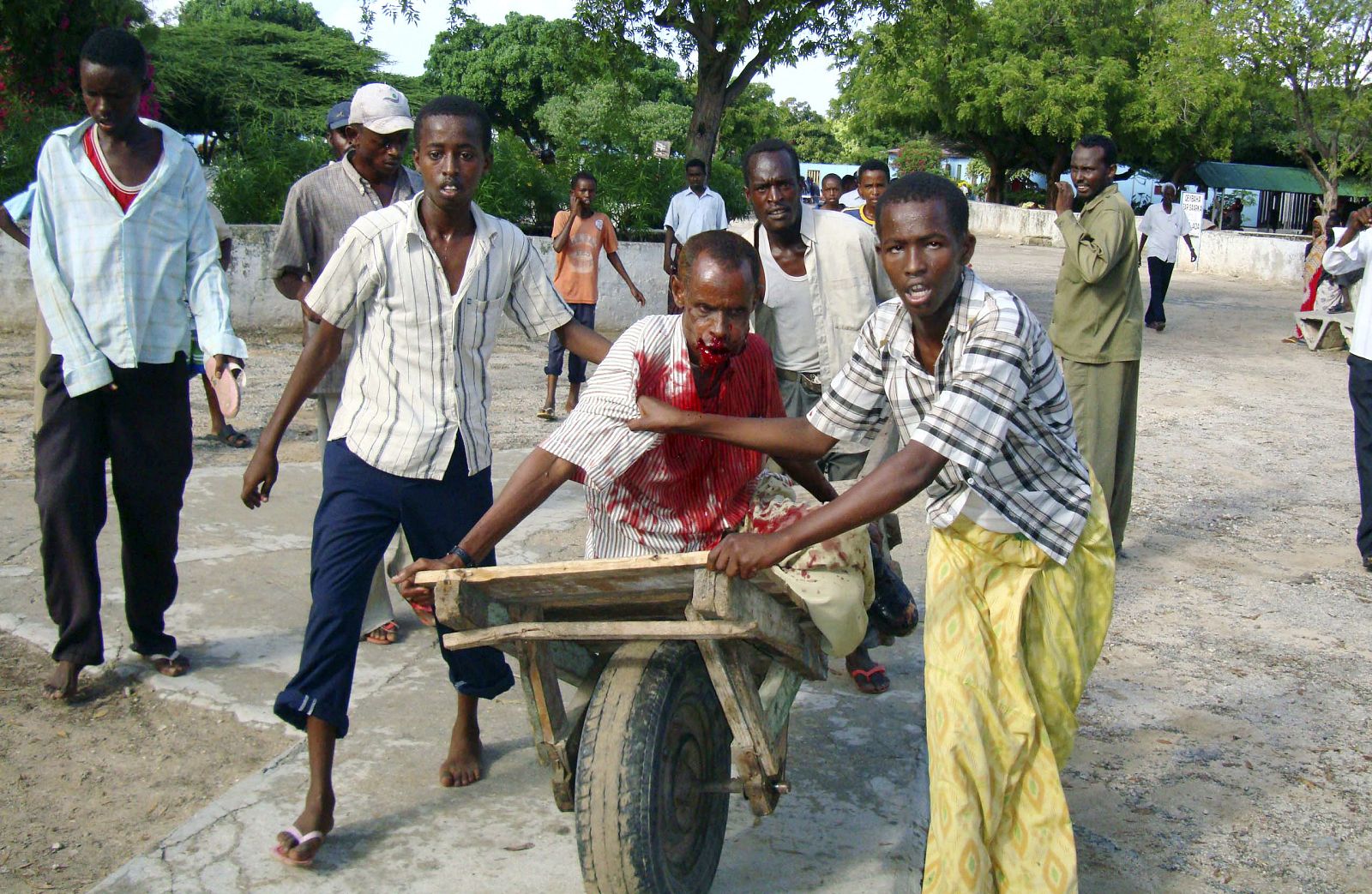 Civilians push a wounded man, caught in a cross-fire during renewed clashes with hardline Islamist fighters, on a wheelbarrow in the capital Mogadishu