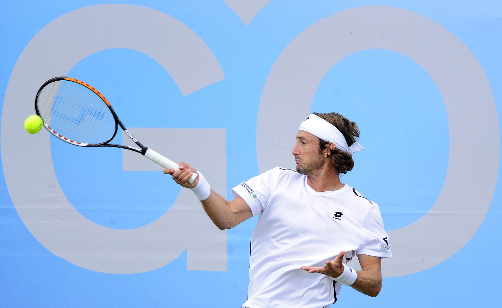 Juan Carlos Ferrero of Spain returns the ball during his match against Xavier Malisse of Belgium at the Queen's Club grass court tennis championships in London