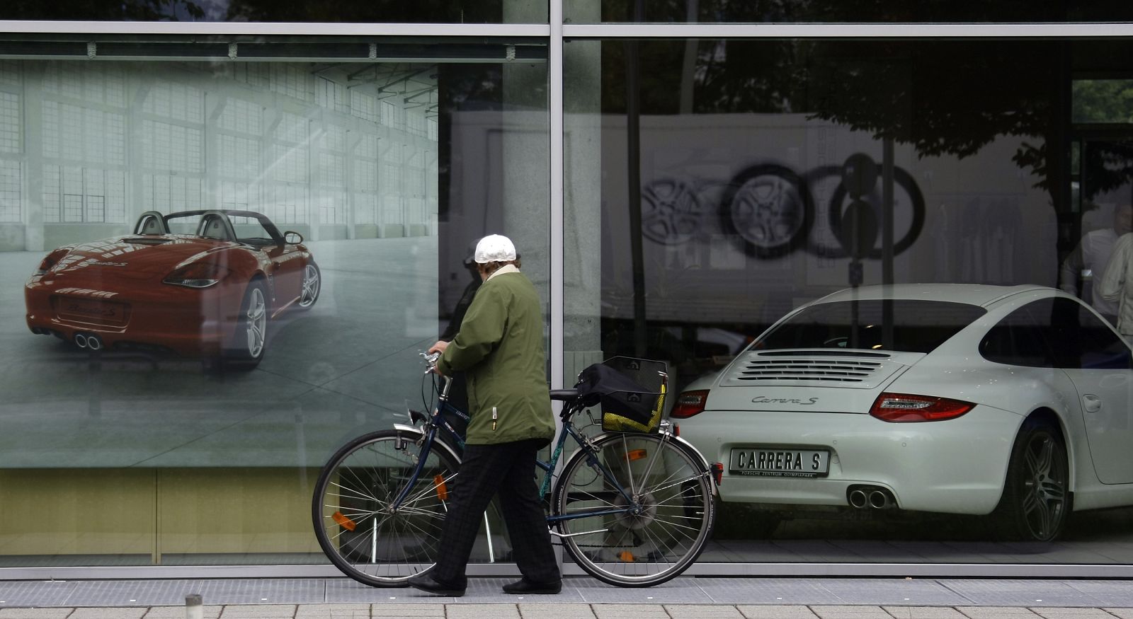 Una ciclista pasea andando por la acera