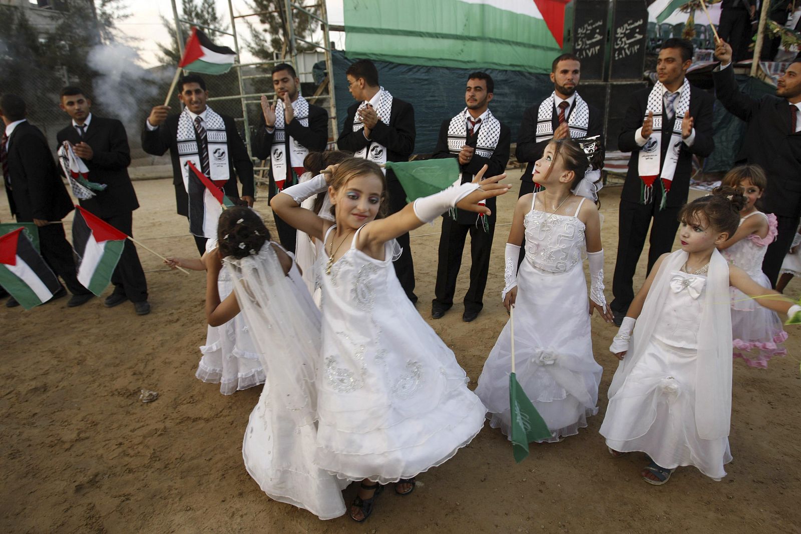Niñas palestinas bailan ante los novios en una boda masiva en Gaza