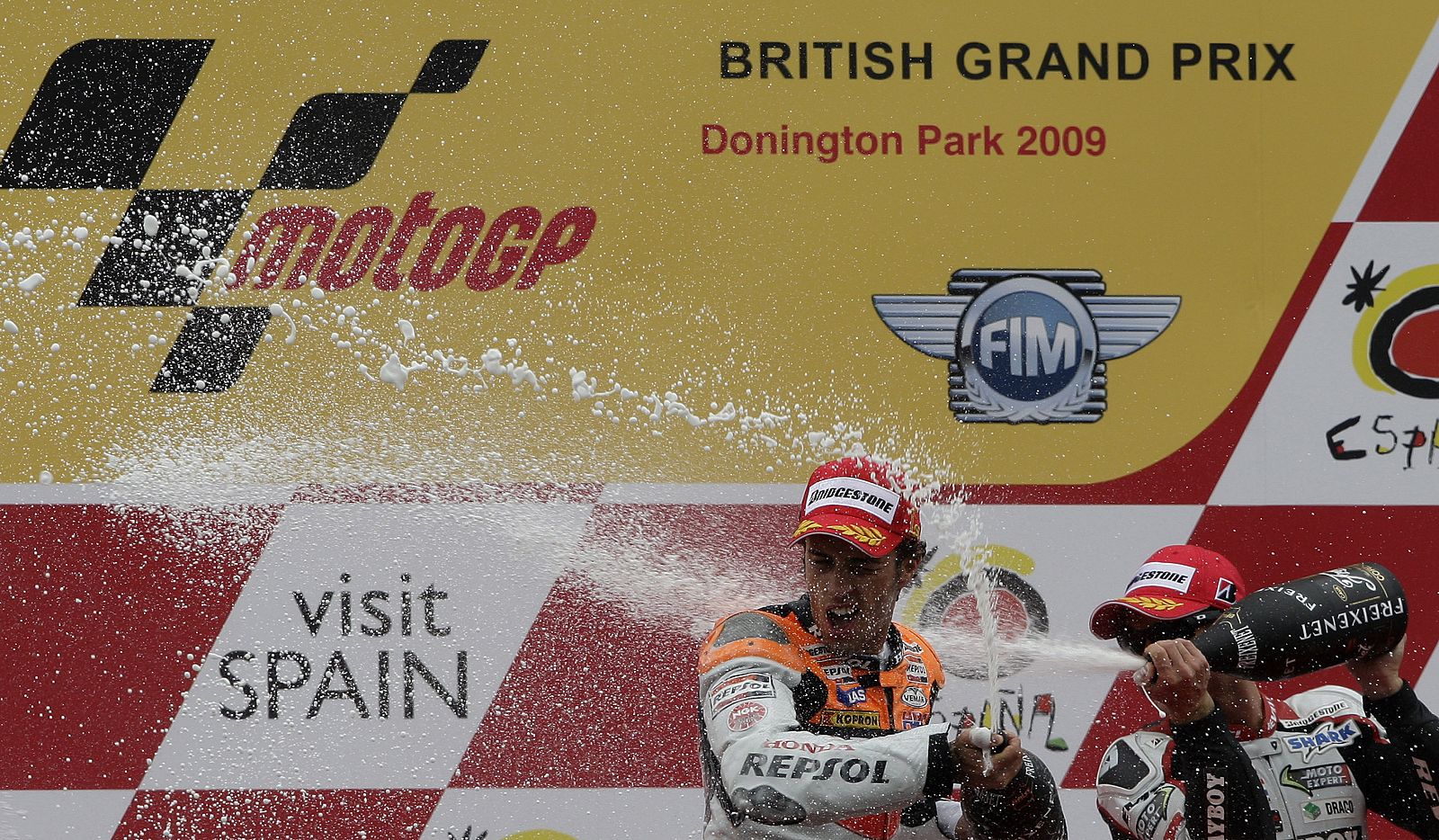 Honda MotoGP rider Dovizioso of Italy celebrates with third place Honda rider de Puniet of France after winning the British Motorcycling Grand Prix at the Donington Park circuit