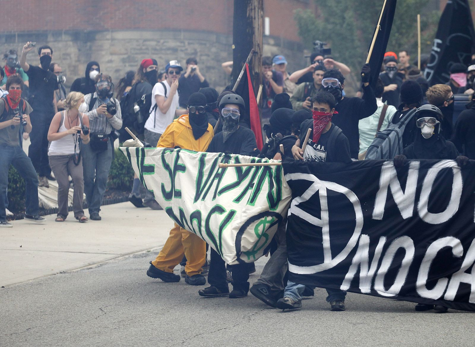 Demonstrators walk away from pepper gas released by police during a protest prior to the start of the G20 Pittsburgh Summit in Pennsylvania