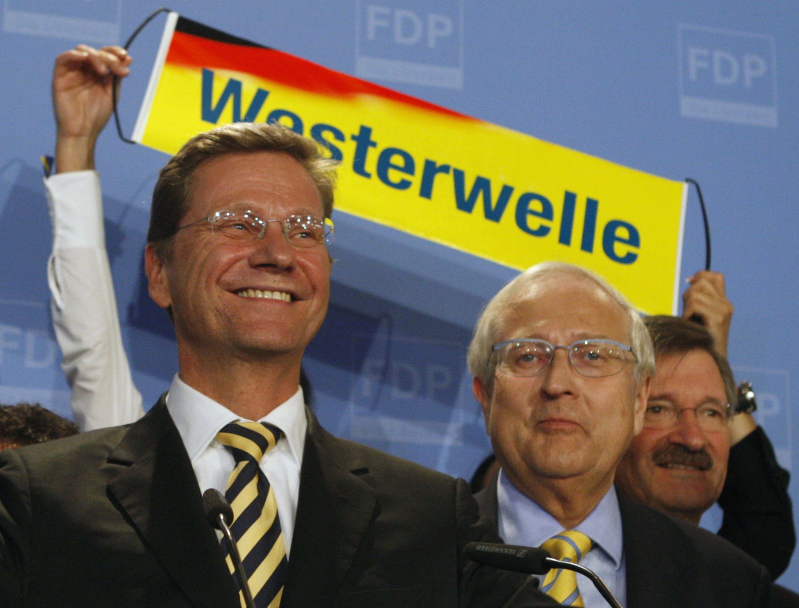 Westerwelle, leader of the pro-business Free Democratic Party (FDP), FDP deputy parliamentary leader Bruederle and Solms react after first exit polls in the German general election (Bundestagswahl) in Berlin