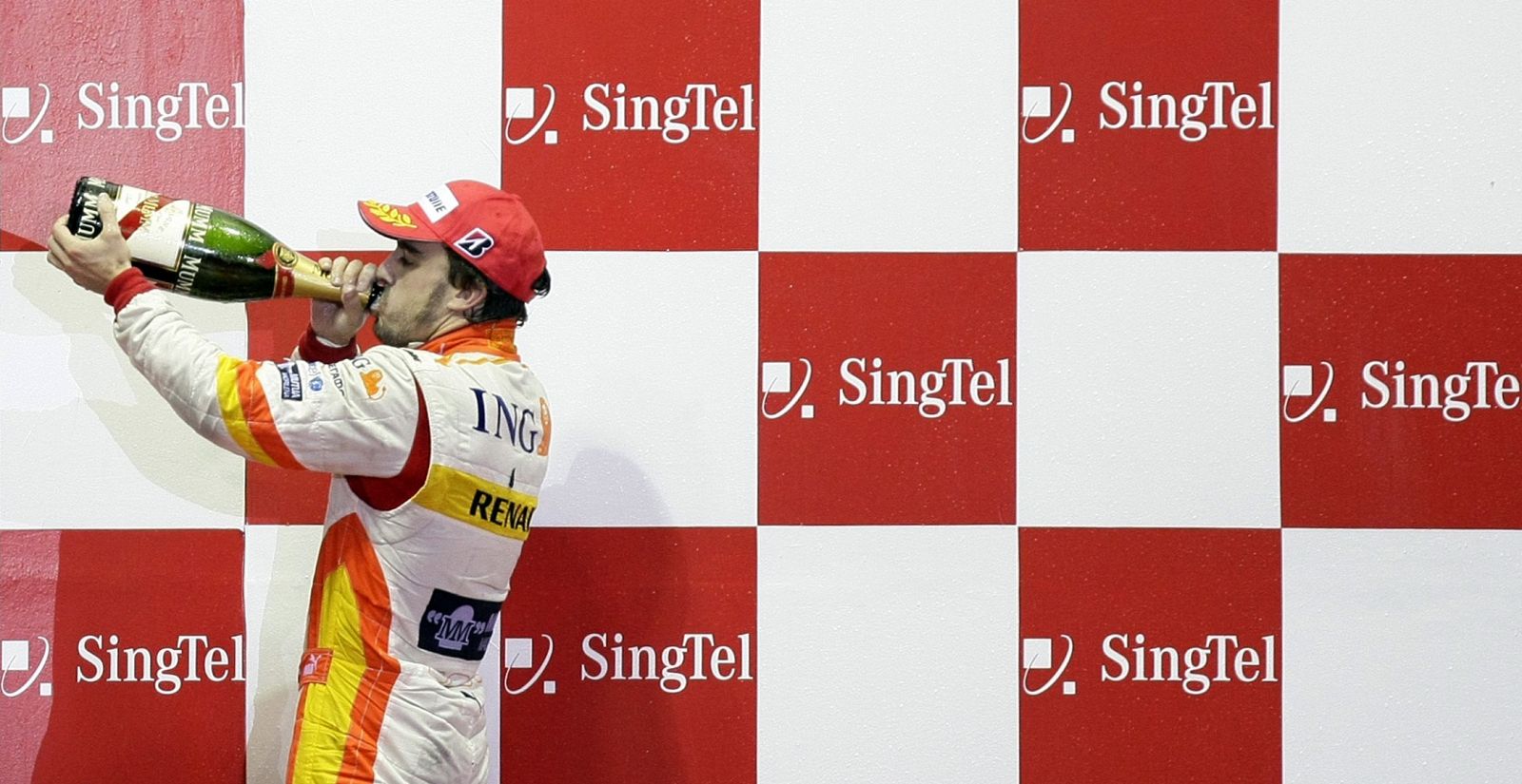 Fernando Alonso celebra con champán su tercer puesto en el GP de Singapur.