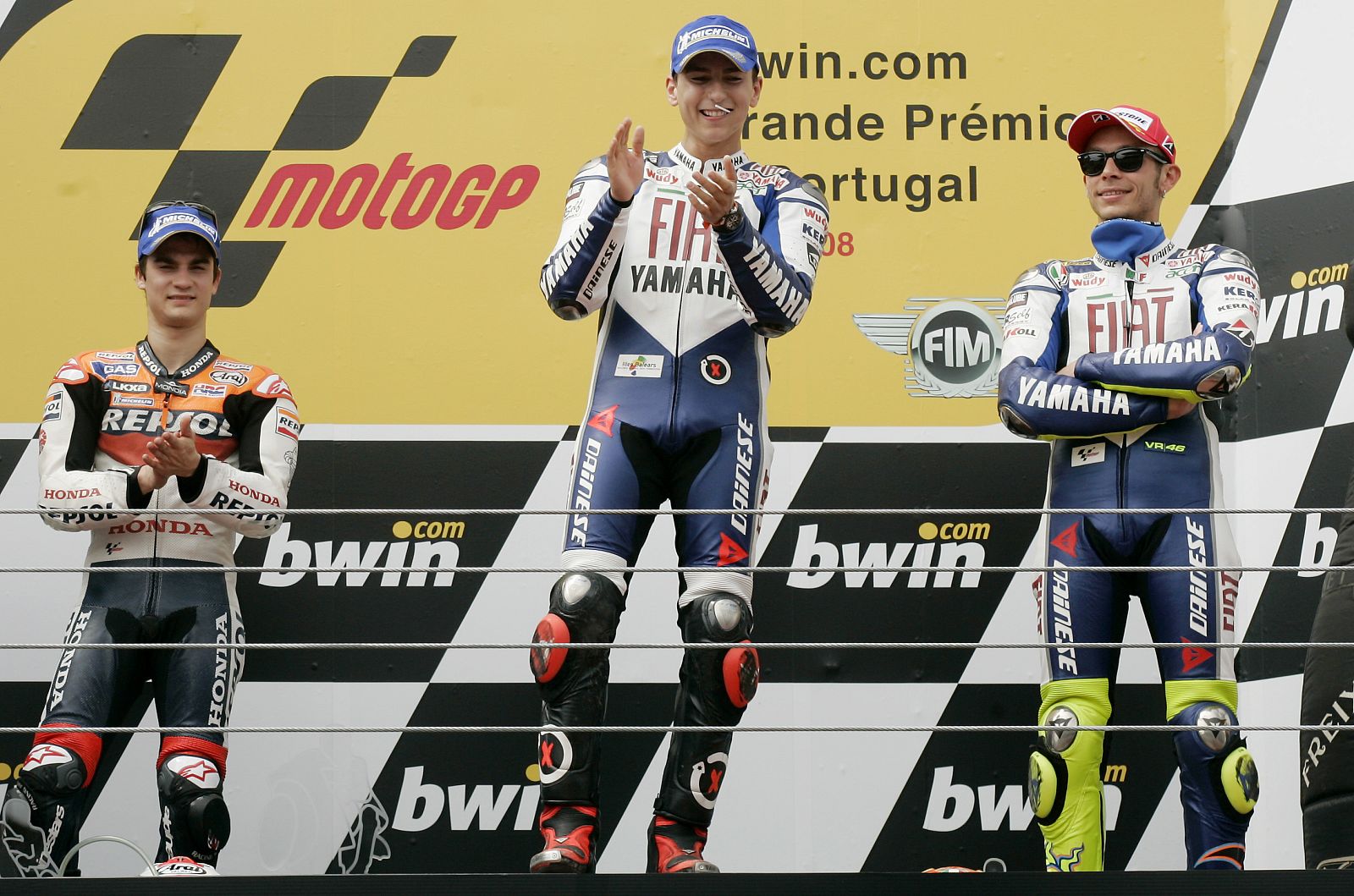 Yamaha MotoGP rider Lorenzo celebrates his victory on the podium next to compatriot Pedrosa and Rossi in Estoril