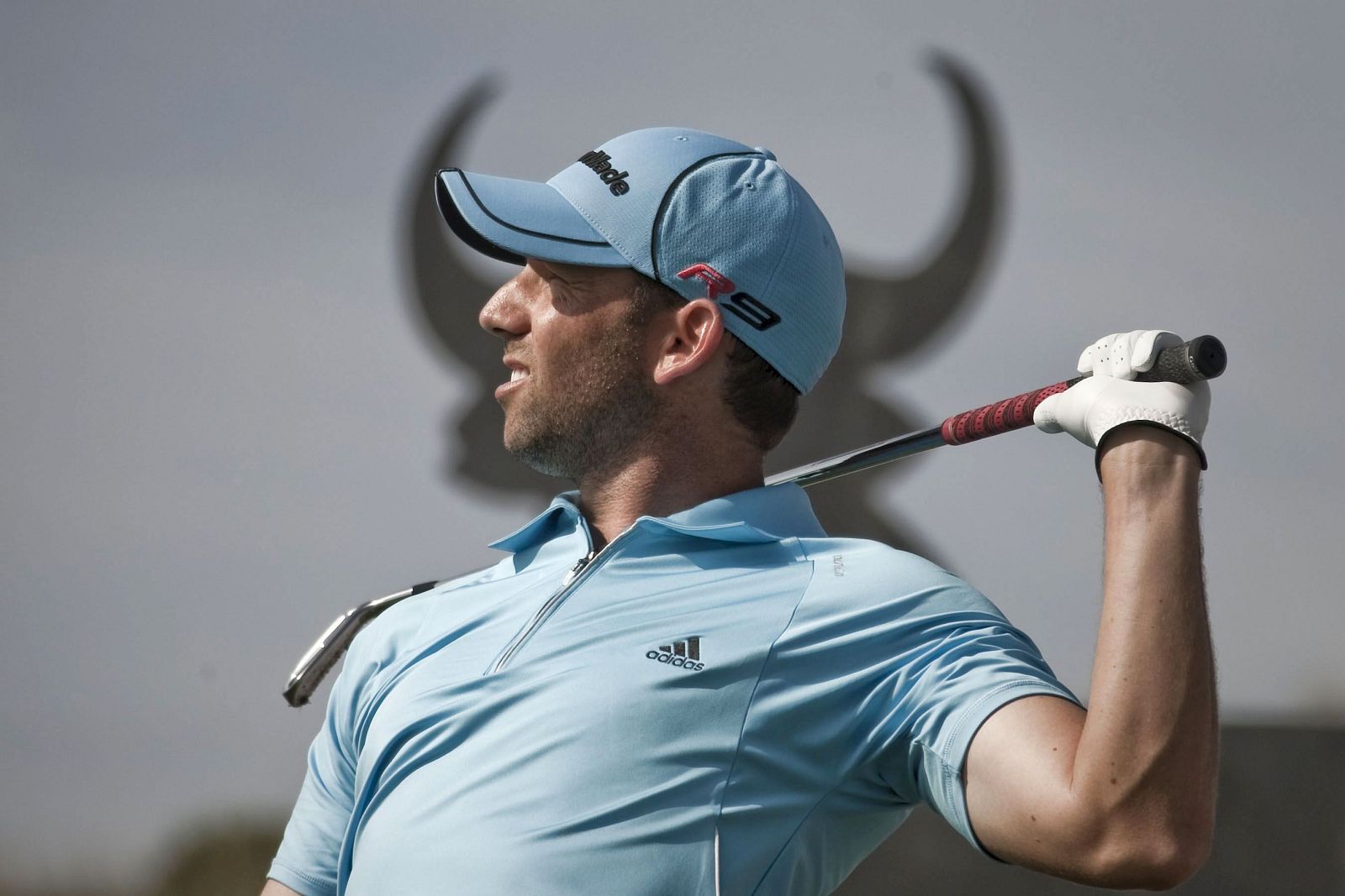 Sergio García observa una bola con una imagen del famoso toro del anuncio al fondo.