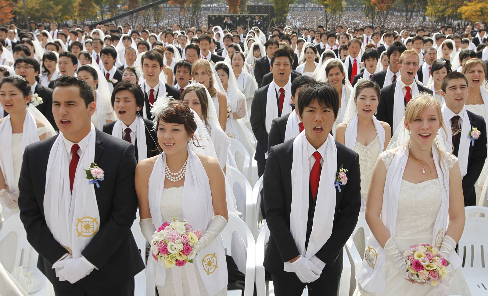 Newlyweds answer the affirmation of vows during a mass wedding ceremony of the Unification Church at Sun Moon University in Asan