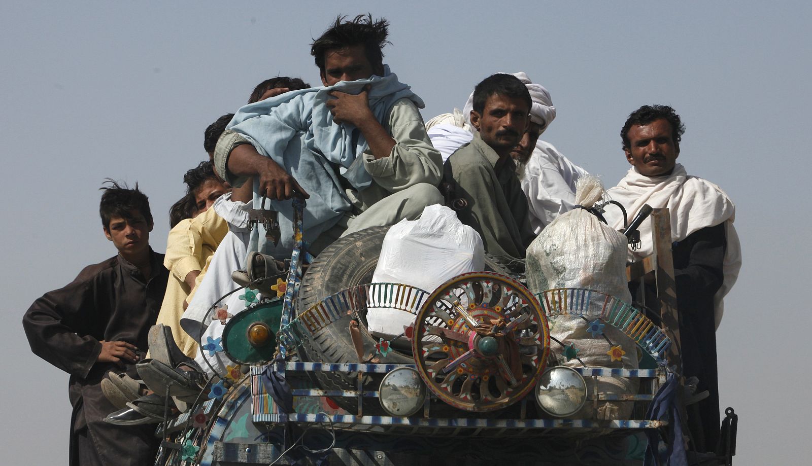 Residents fleeing a military offensive against the Pakistani Taliban sit on top of a vehicle while entering Dera Ismail Khan from South Waziristan