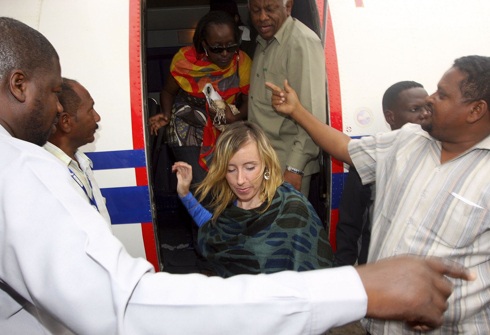 Released hostages Commins and Kawuki disembark from a plane on arrival at Khartoum airport