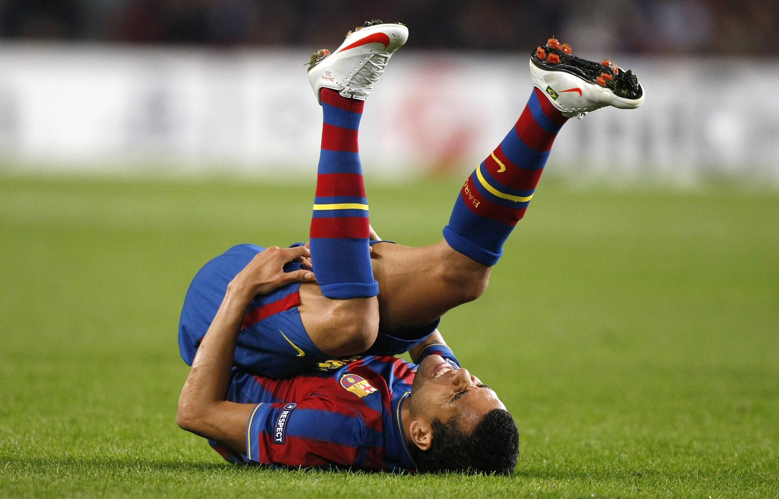 Barcelona's Dani Alves grimaces after being tackled by a Rubin Kazan player during their Champions League soccer match at the Camp Nou stadium in Barcelona