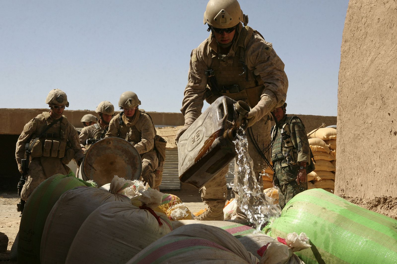 El ejército estadounidense vierte gasolina sobre sacos de droga en la provincia de Helmanadade-Afghanistan, pour gasoline on bags of confiscated poppy seeds in Helmand