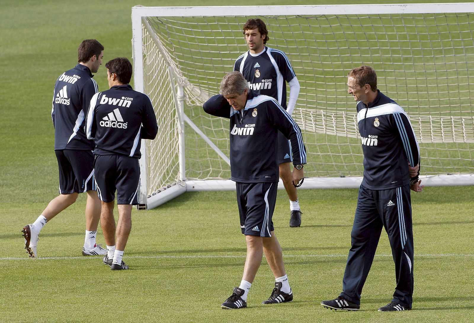 Pellegrini habla con su ayudante mientras los jugadores se ejercitan