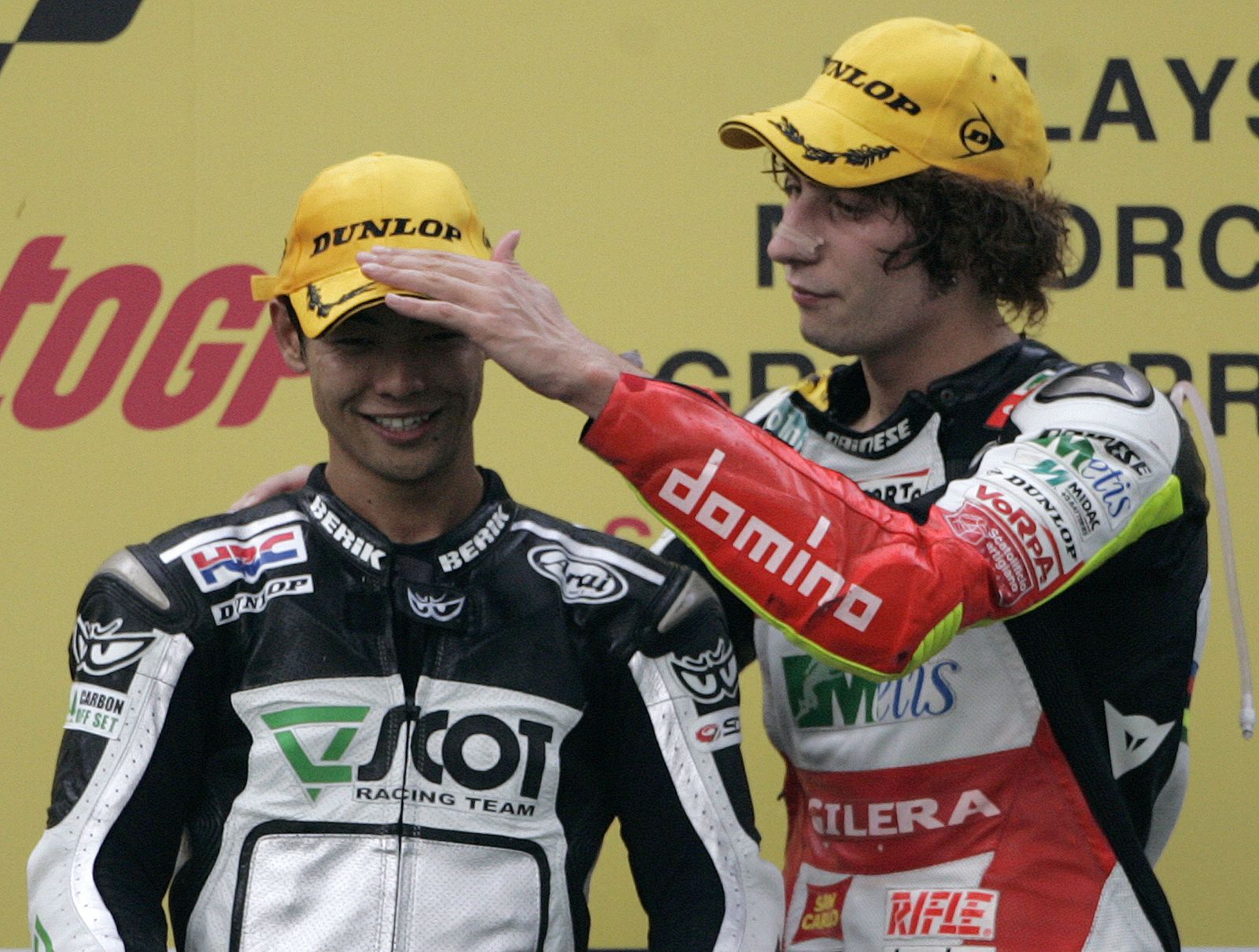 Honda 250cc rider Aoyama gets a pat from Gilera 250cc rider Simoncelli during the Malaysian Grand Prix near Kuala Lumpur