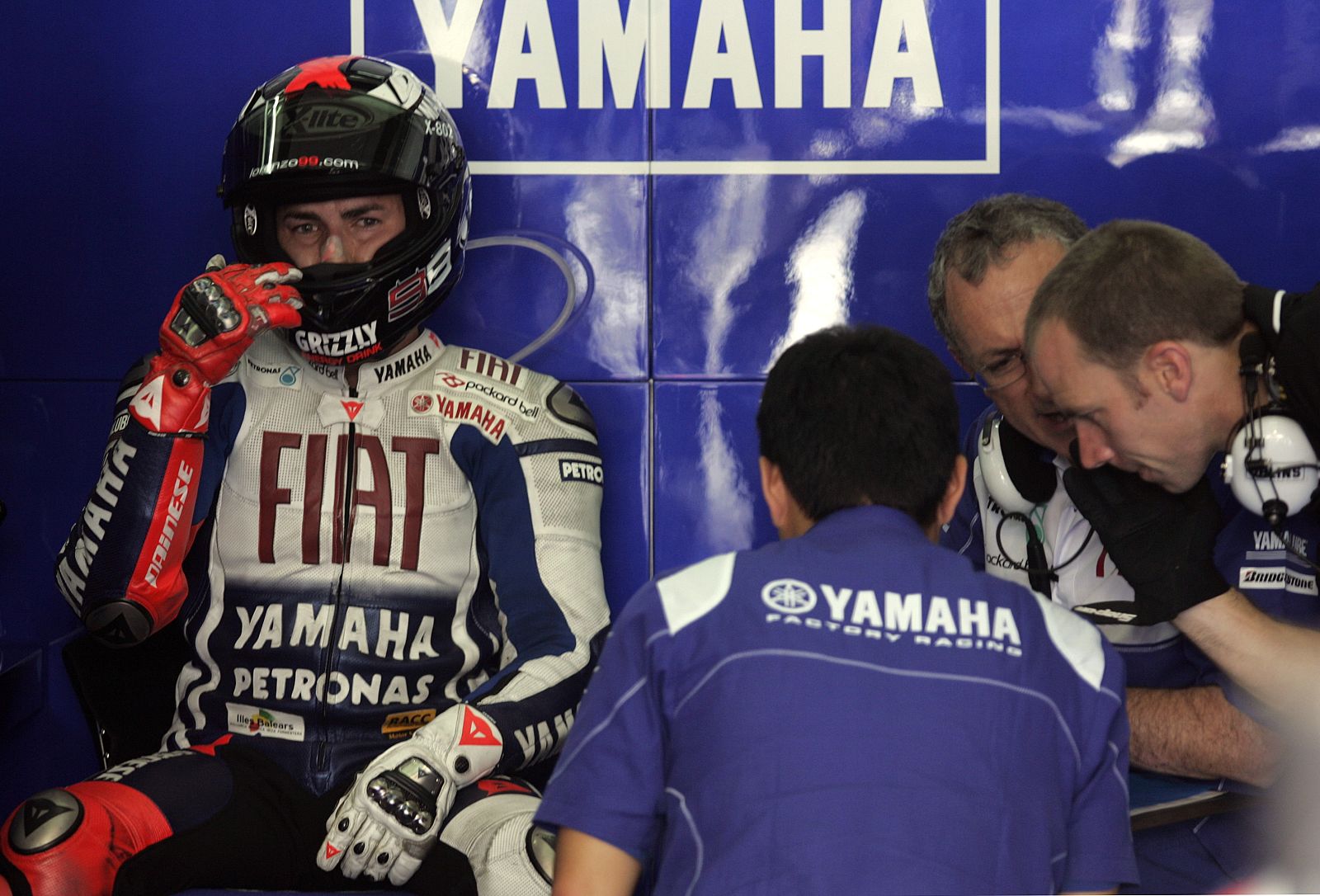 Yamaha MotoGP rider Jorge Lorenzo of Spain sits next to his mechanics during the qualifying session in Sepang