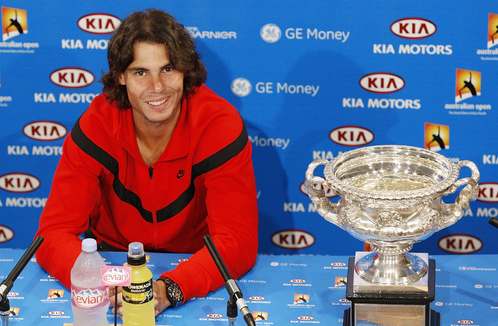 Spain's Nadal smiles at a news conference, next to the trophy, after winning his men's singles final match at the Australian Open
