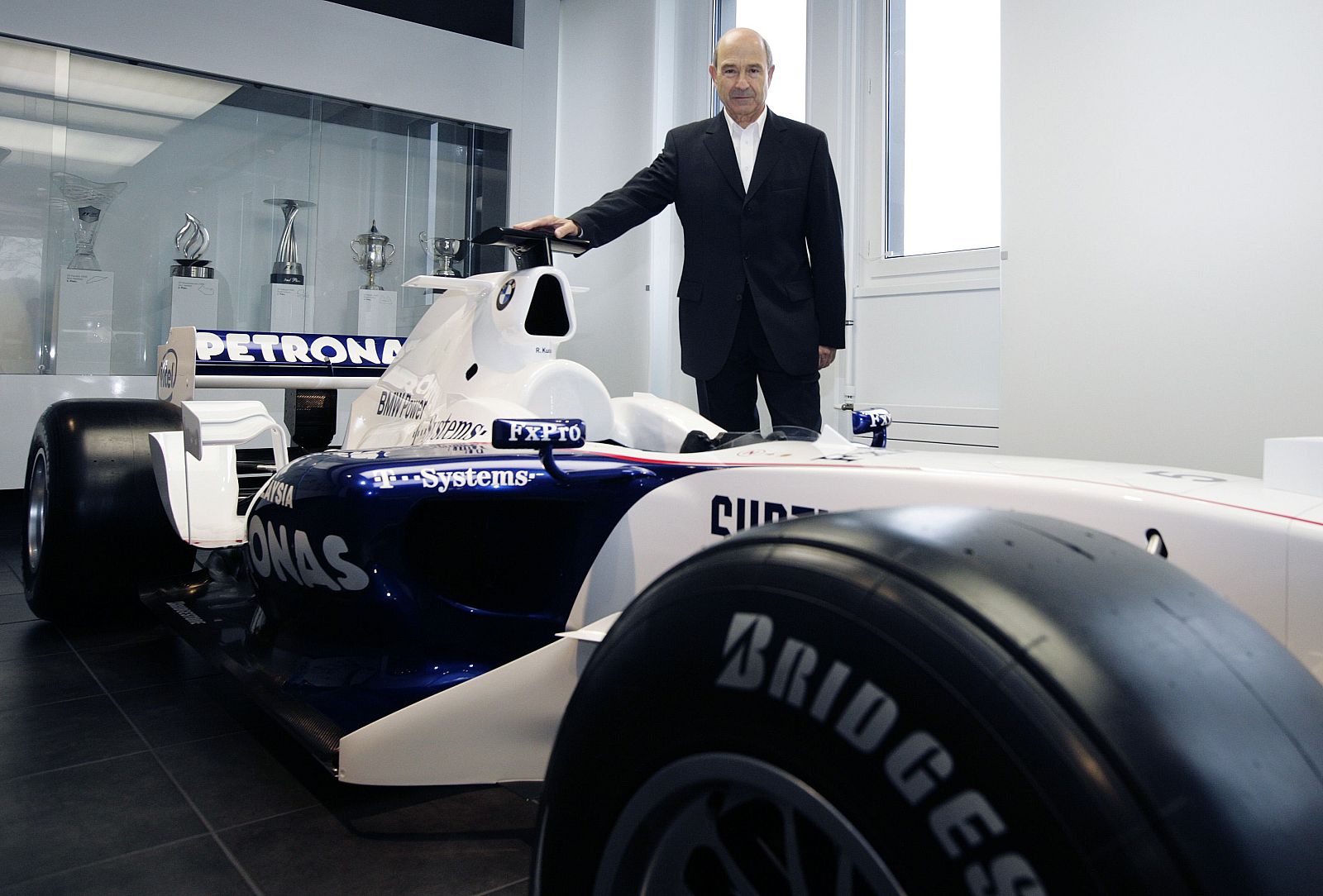 Peter Sauber poses in front of an old Formula 1 car after a news conference in Hinwil