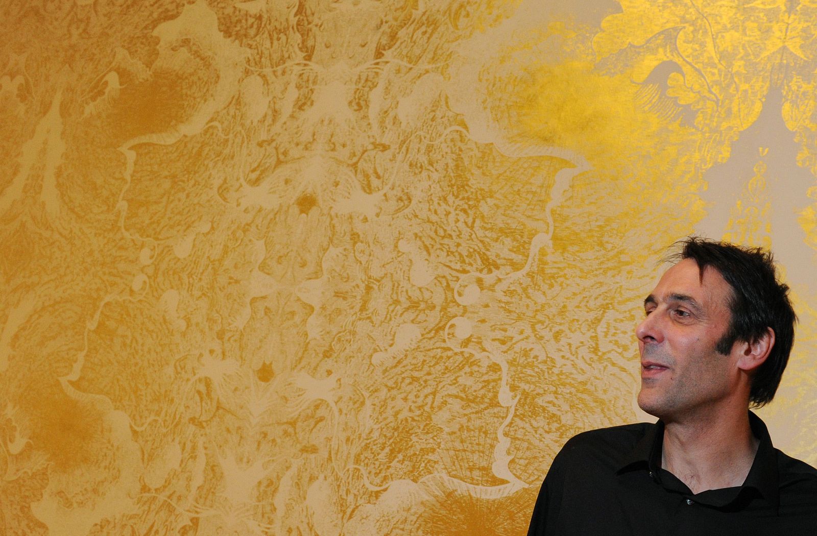 El artista Richard Wright posa junto a su mural "Sin título"