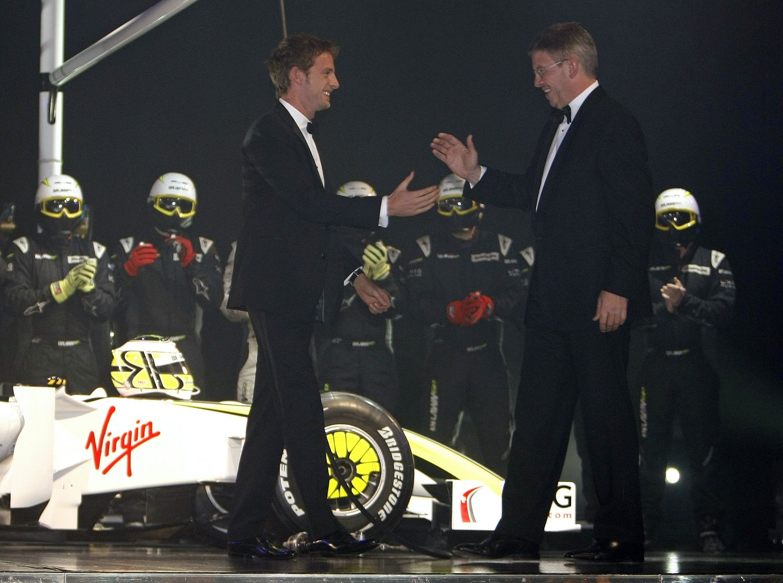 British Formula One driver Jenson Button shakes hands with Brawn GP Formula One team principal Ross Brawn during the 2009 FIA prize presentation gala in Monaco